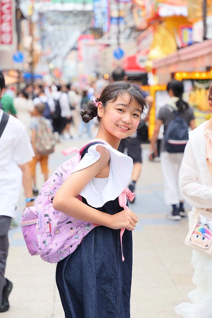 商店街で振り返り笑う女の子