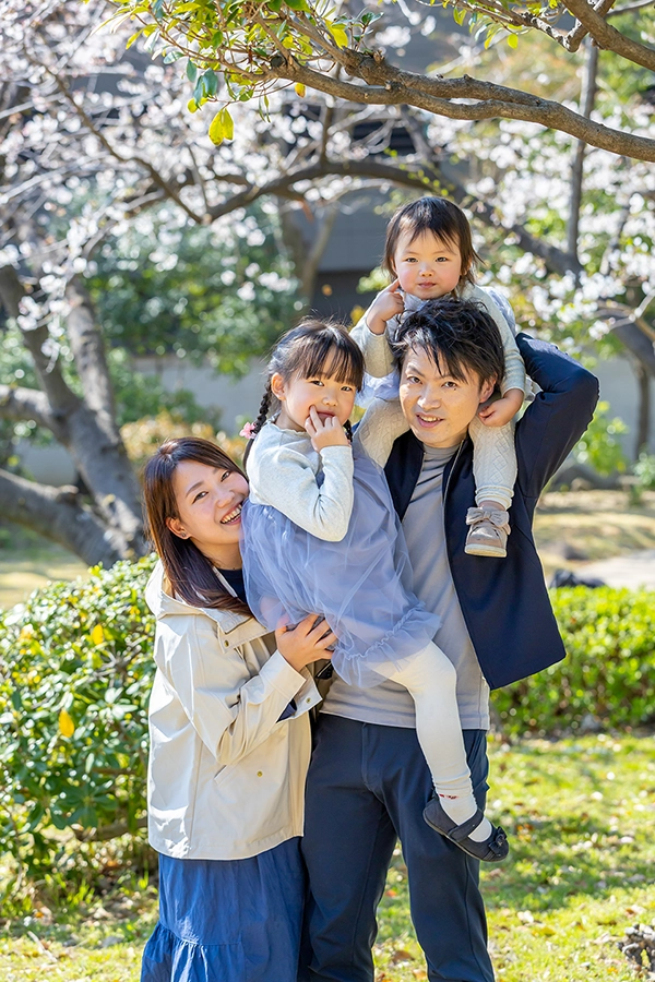 桜の木の下で笑顔の4人家族