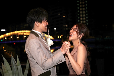 向かい合って手を繋ぎ笑い合う夫婦