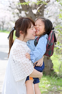頬をくっつけて笑う母と子